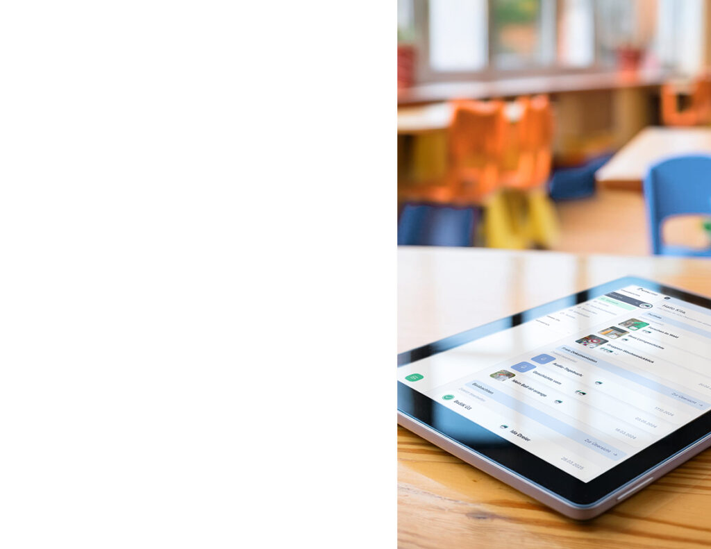 Tablet mit geöffneter KITALINO-App auf einem Holztisch in einer Kita-Umgebung